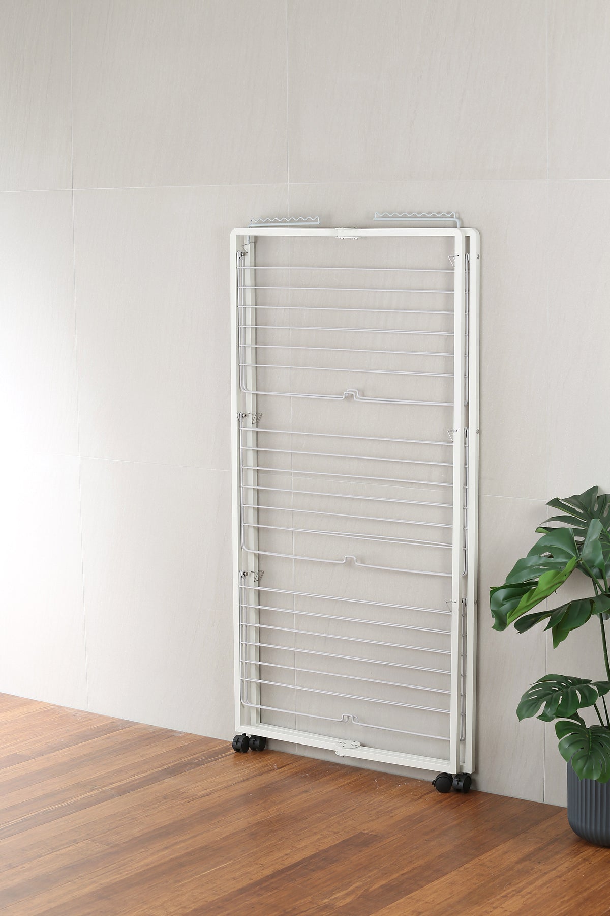Rotating hanging arm on the white tower airer holding shirts on hangers
