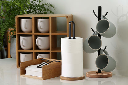Bamboo napkin holder on a kitchen bench holding a stack of white napkins under the black metal arm