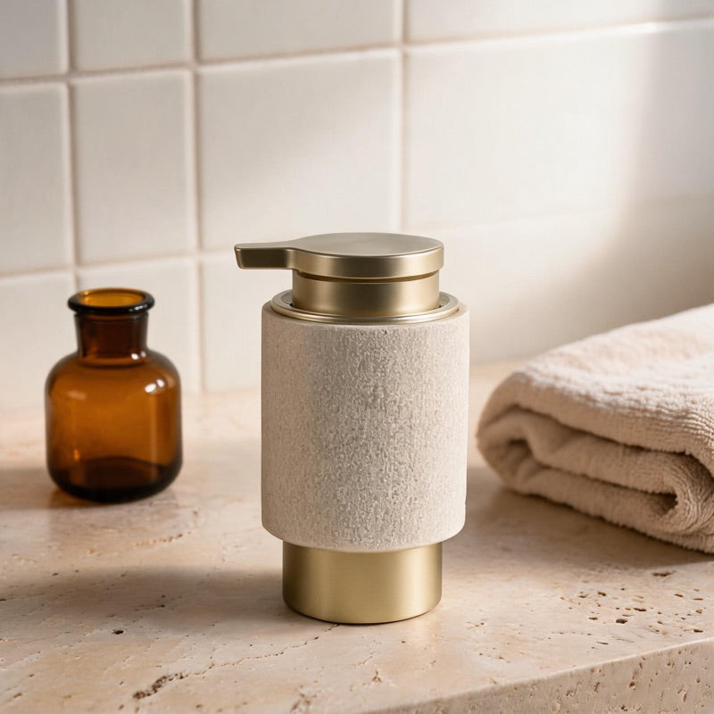 A textured gold-sand resin WarmyNest soap dispenser with brass trim